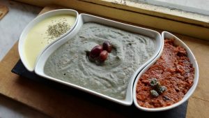 Trittico multicolore: spuma di senape, crema di melanzane e Tahina, crema rossa alle olive nere
